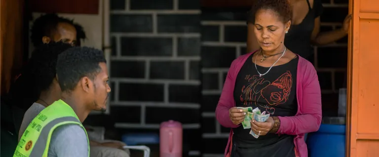 A woman counting banknotes at her stall in Ethiopia